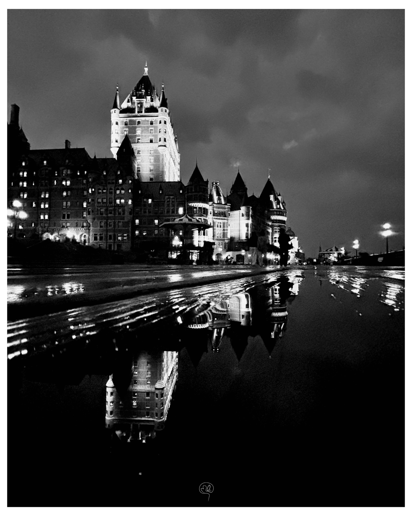 Château Frontenac illuminé et reflété sur une chaussée mouillée